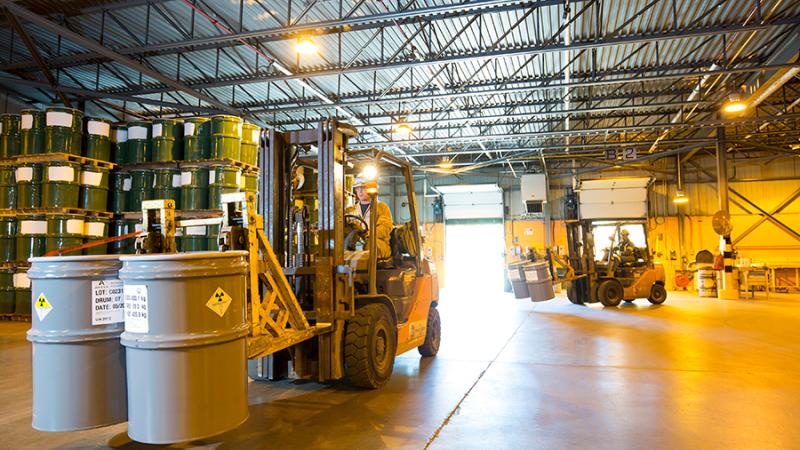 Workers move drums of uranium concentrates received from all over the world at the Blind River refinery.  